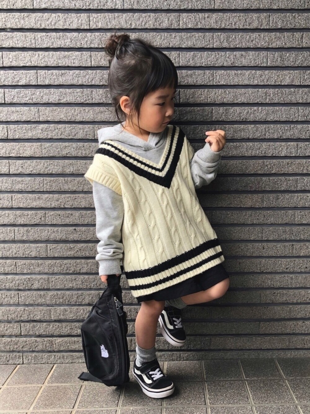 ホワイト系のワンピース、グレー系のパーカー、ブラック系のスカートを着用したキッズの春コーディネートの1枚目の写真
