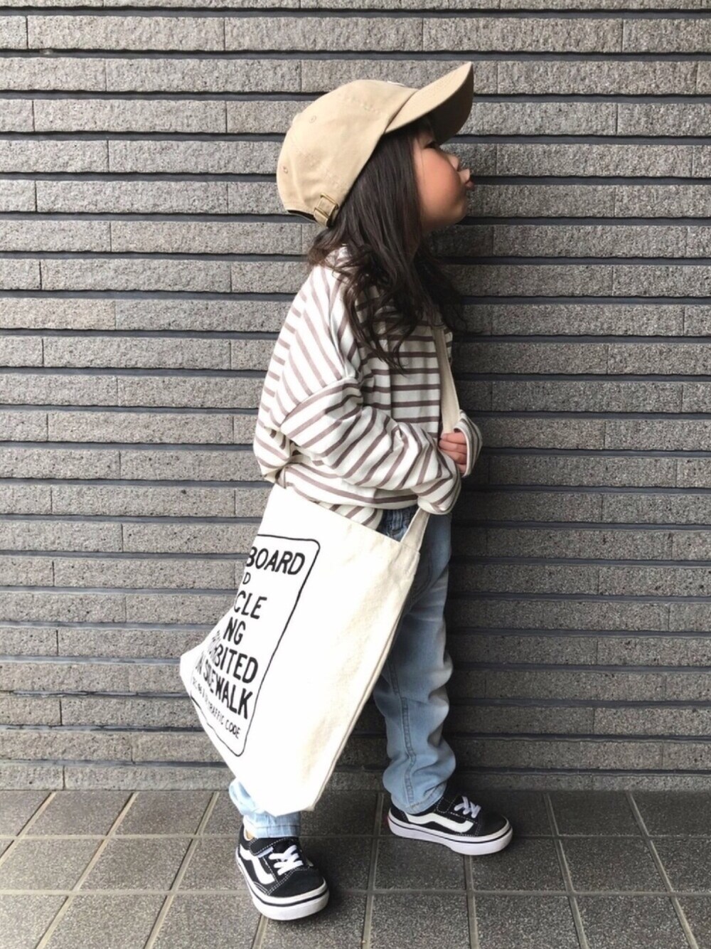 ベージュ系のTシャツ/カットソー、ブルー系のデニムパンツ、ブラック系のスニーカーを着用したキッズの春コーディネートの1枚目の写真