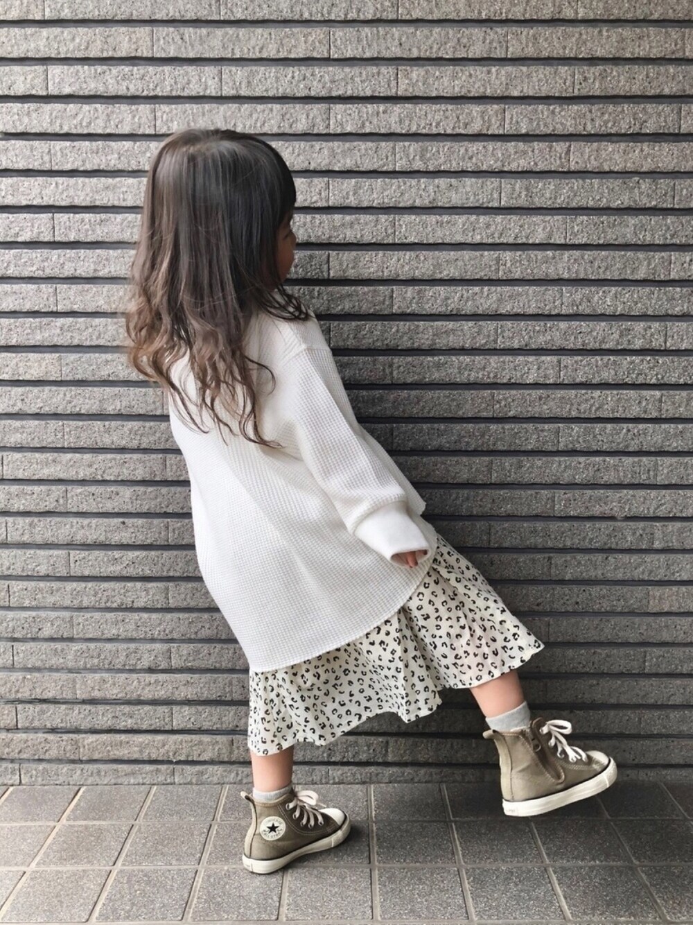 ホワイト系のTシャツ/カットソー、ホワイト系のスカート、グリーン系のスニーカーを着用したキッズの春コーディネートの1枚目の写真