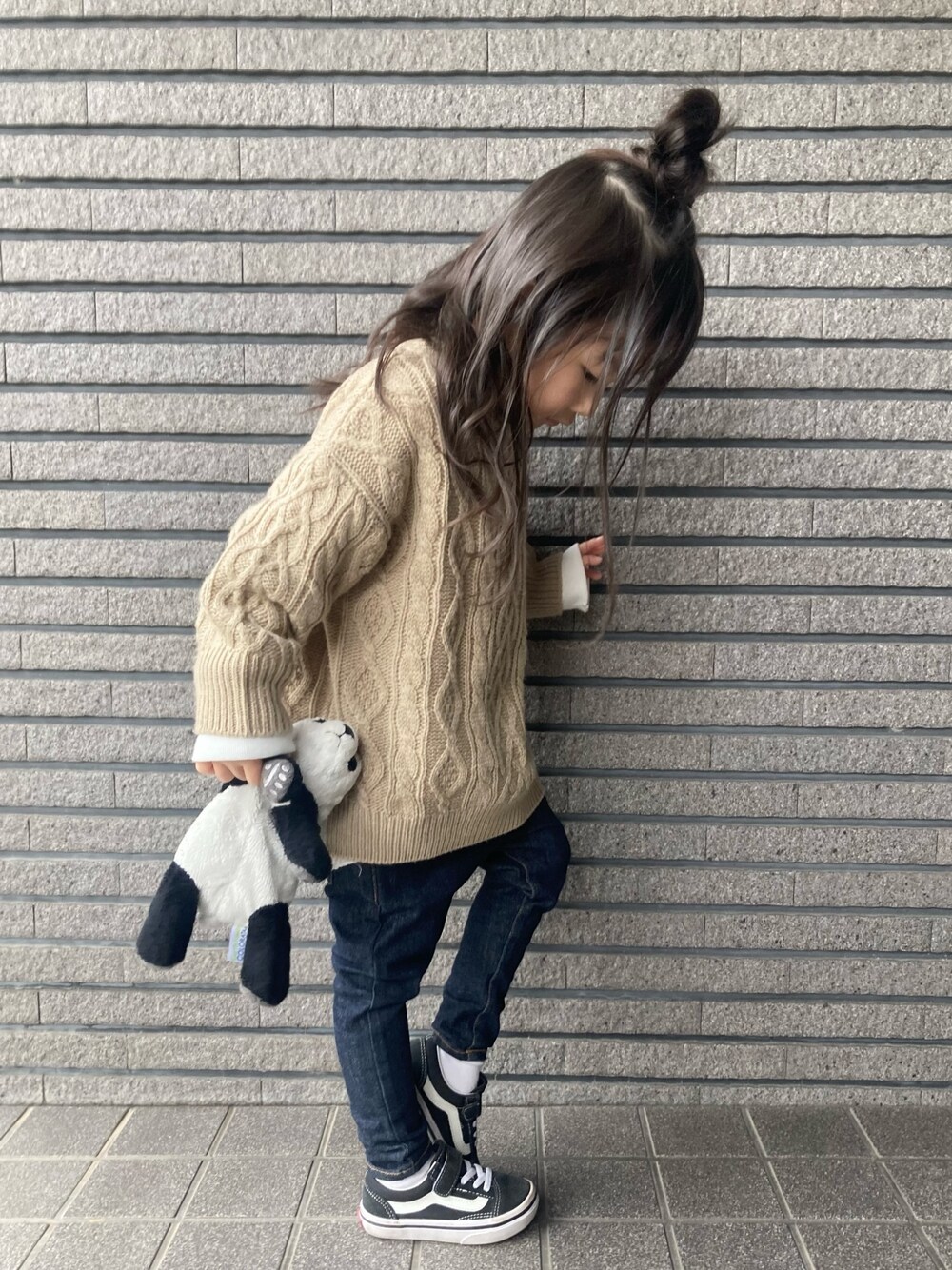 ベージュ系のニット/セーター、ホワイト系のTシャツ/カットソー、ブルー系のデニムパンツを着用したキッズの冬コーディネートの1枚目の写真