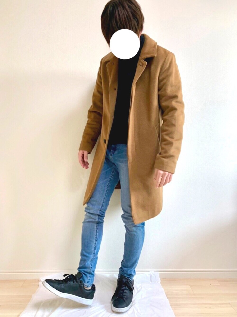 ブラック系のスニーカー、ブルー系のパンツ、ブラック系のニット/セーターを着用したメンズの冬コーディネートの1枚目の写真