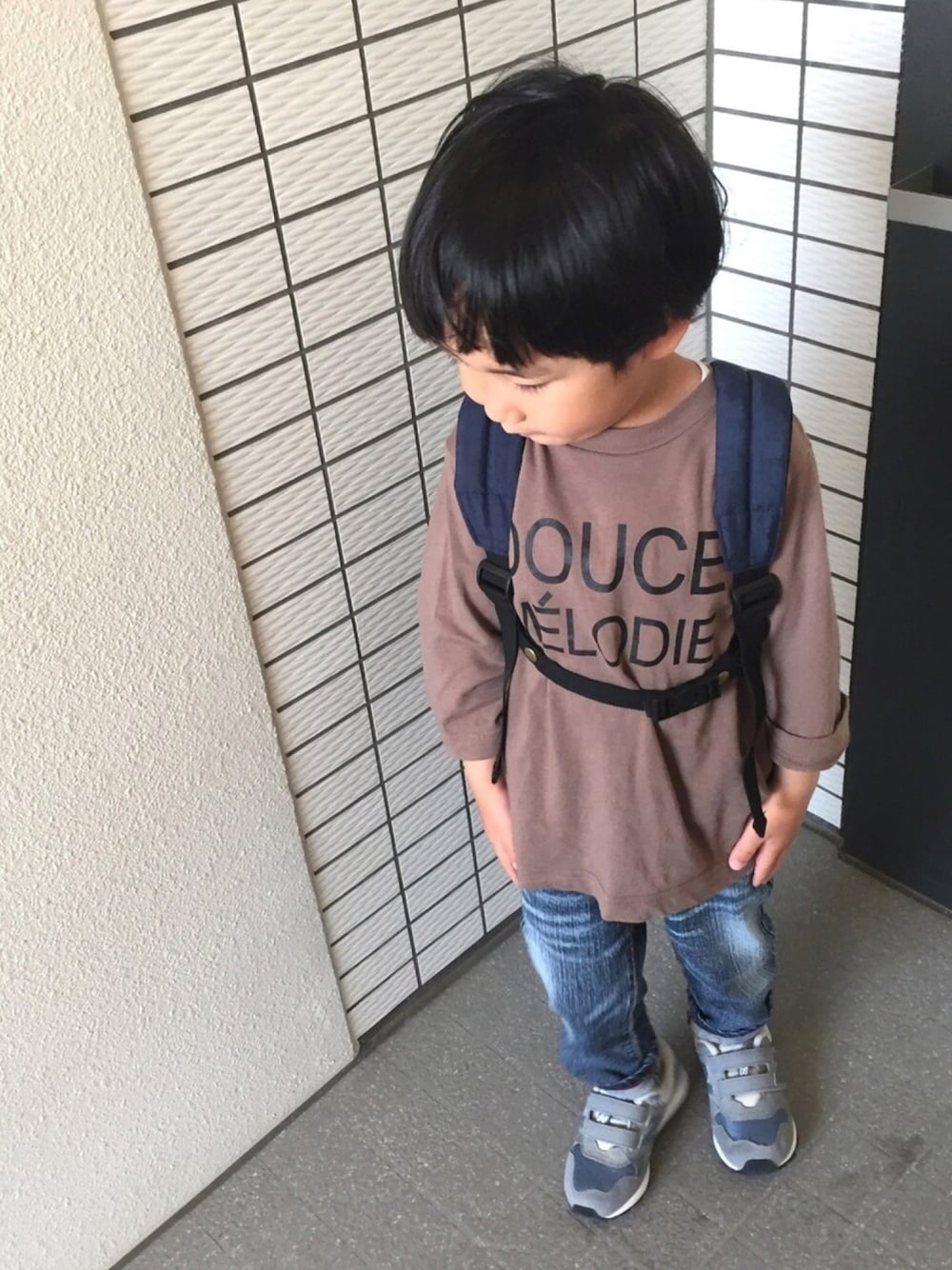 ブラウン系のTシャツ/カットソー、ブルー系のデニムパンツ、グレー系のスニーカーを着用したキッズの春コーディネートの1枚目の写真