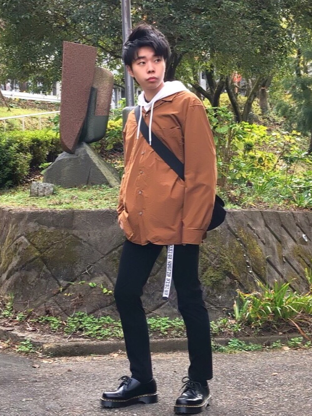 ブラウン系のシャツ/ブラウス、ブラック系のブーツ、ブラック系のデニムパンツを着用したメンズの秋コーディネートの1枚目の写真