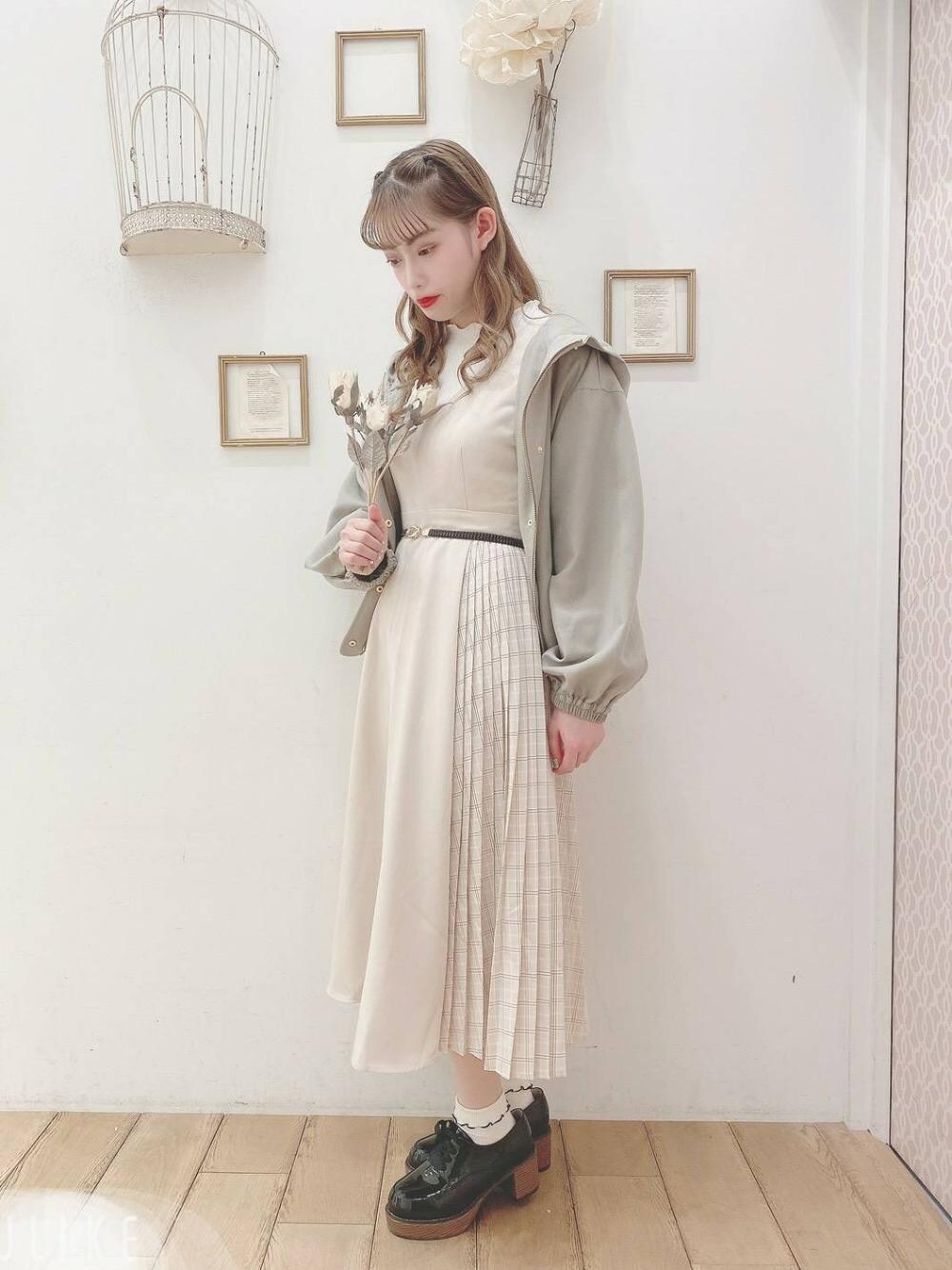 グリーン系のブルゾン、ブラック系のその他シューズ、ホワイト系のジャンパースカートを着用したレディースの春コーディネートの1枚目の写真