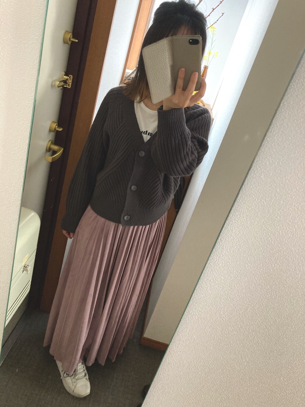 グレー系のカーディガン/ボレロ、パープル系のスカート、ホワイト系のスニーカーを着用したレディースの春コーディネートの1枚目の写真