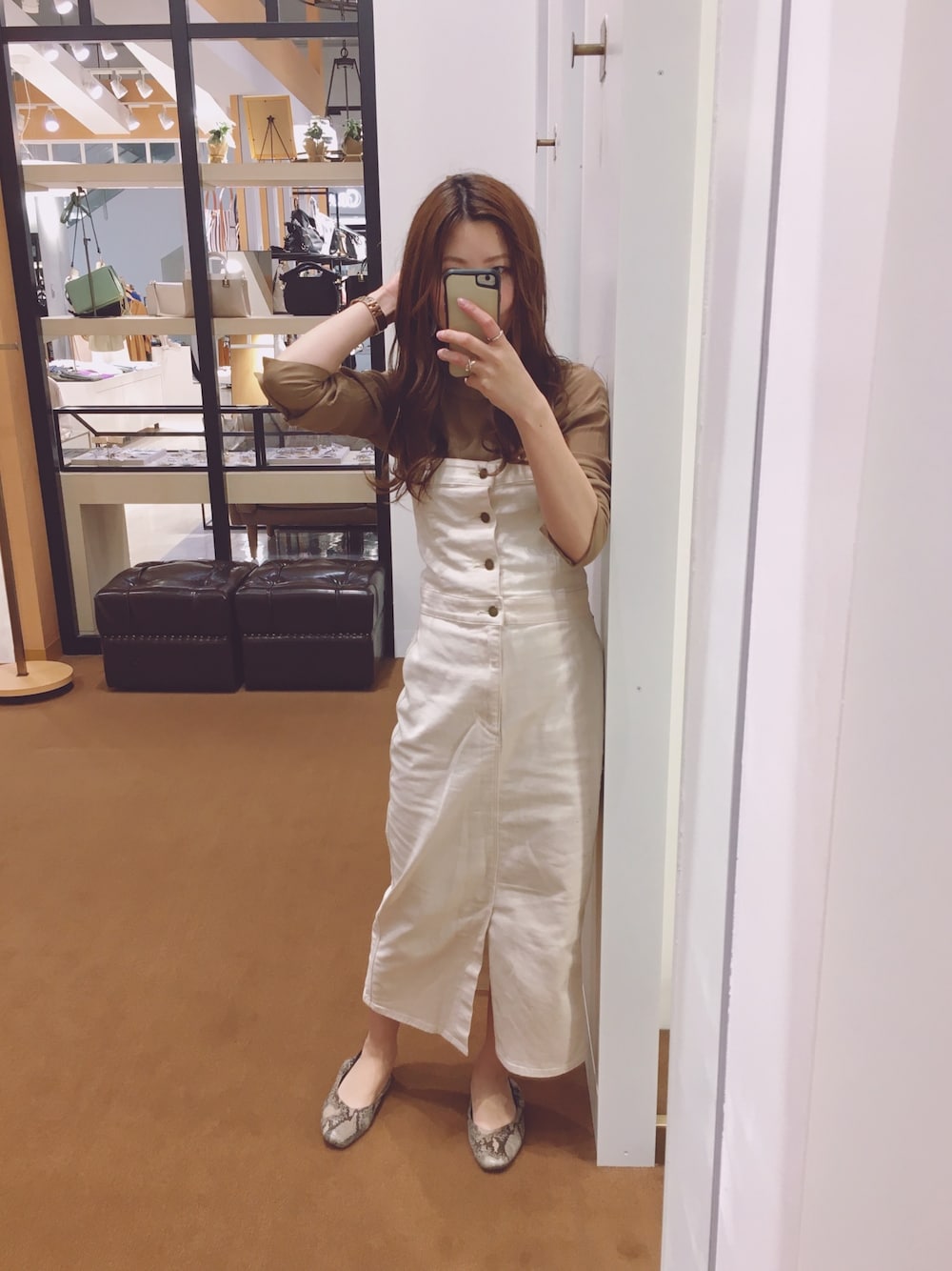 ベージュ系のシャツ/ブラウス、ホワイト系のジャンパースカートを着用したレディースの春コーディネートの1枚目の写真