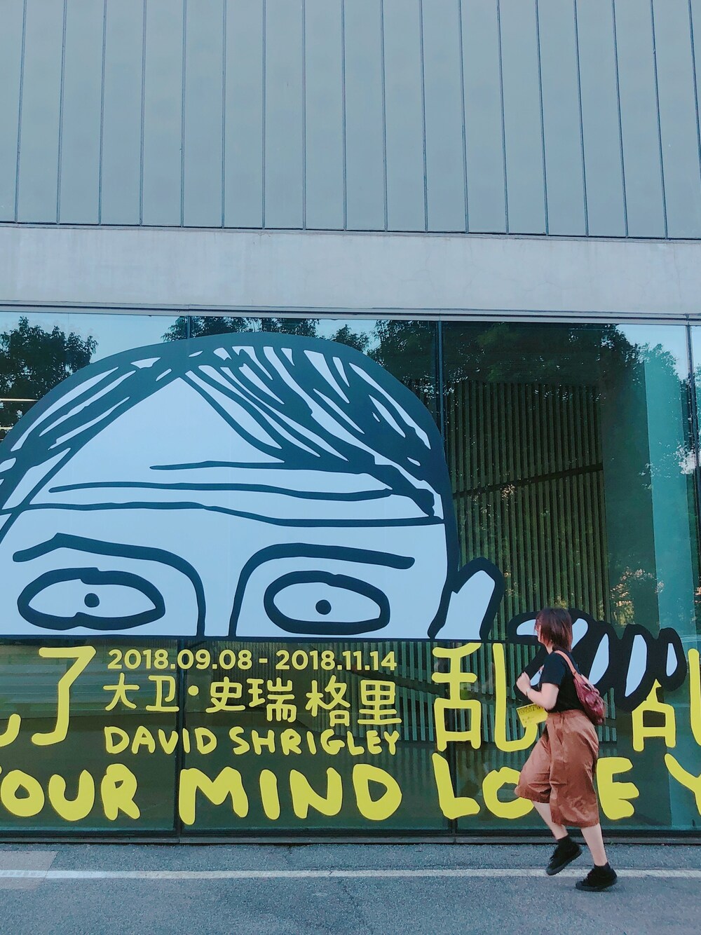 オレンジ系のチノパンツ、オレンジ系のショルダーバッグを着用したレディースの秋コーディネートの1枚目の写真