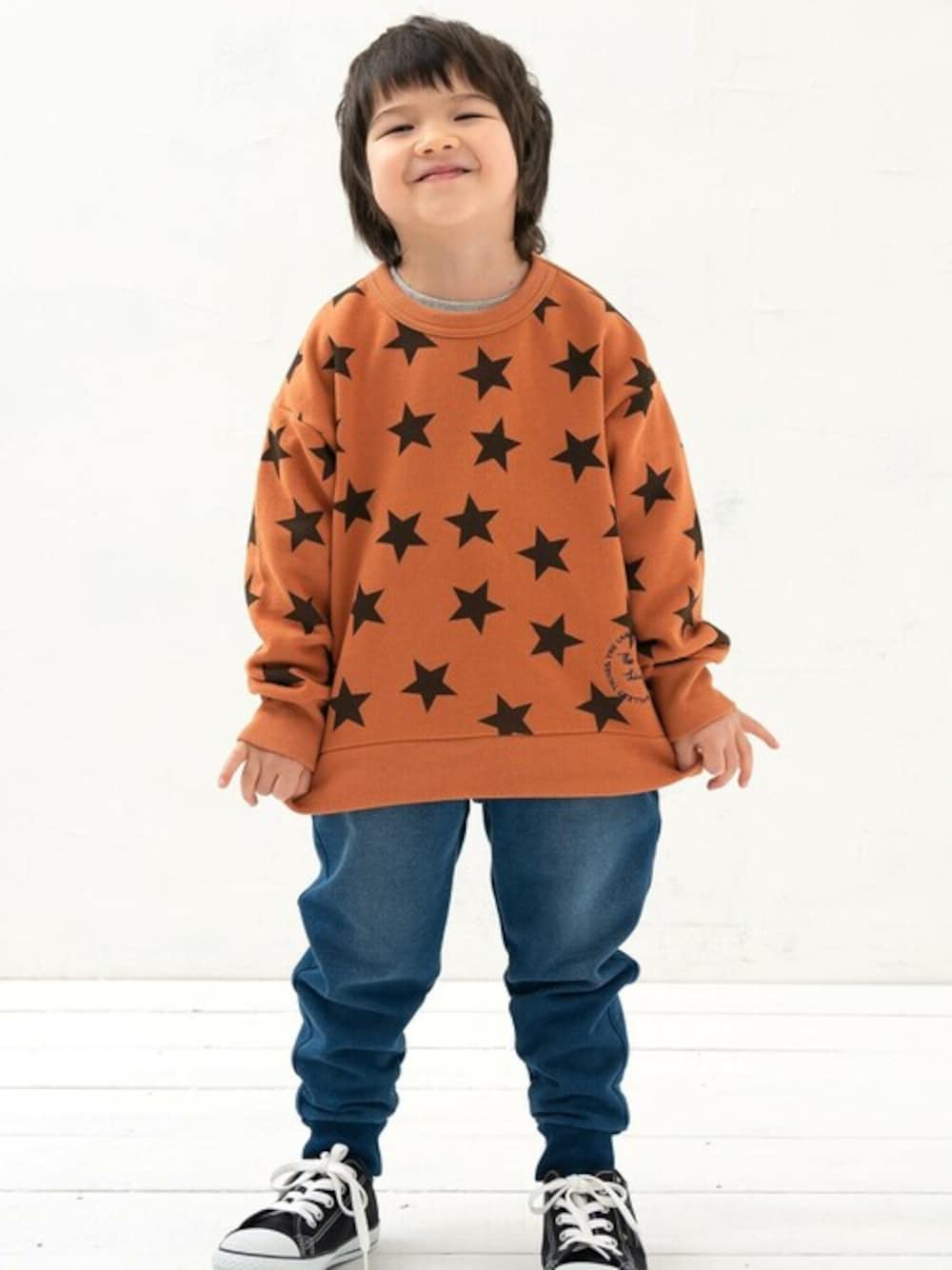 イエロー系のスウェット、ブルー系のデニムパンツを着用したキッズの秋コーディネートの1枚目の写真