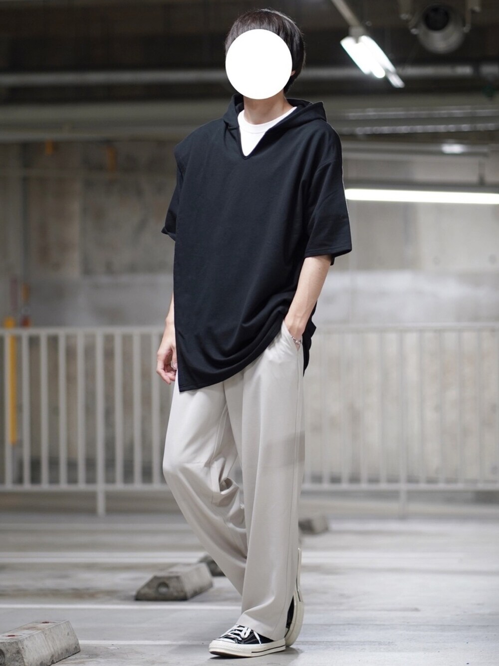 ブラック系のTシャツ/カットソー、ベージュ系のスラックス、ブラック系のスニーカーを着用したメンズの春コーディネートの1枚目の写真