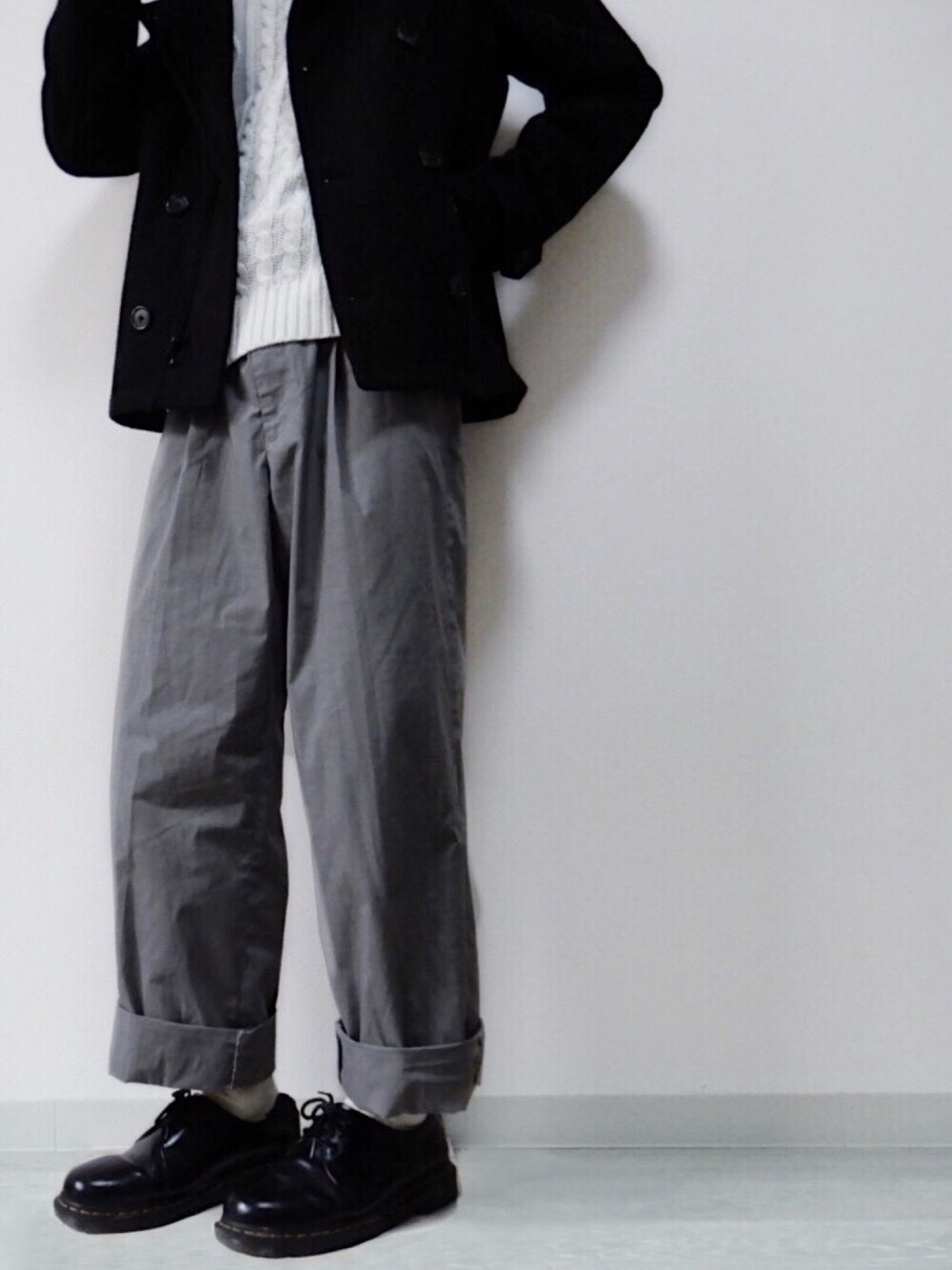 ブラック系のジャケット/アウター、ホワイト系のニット/セーター、ベージュ系のパンツを着用したメンズの冬コーディネートの1枚目の写真