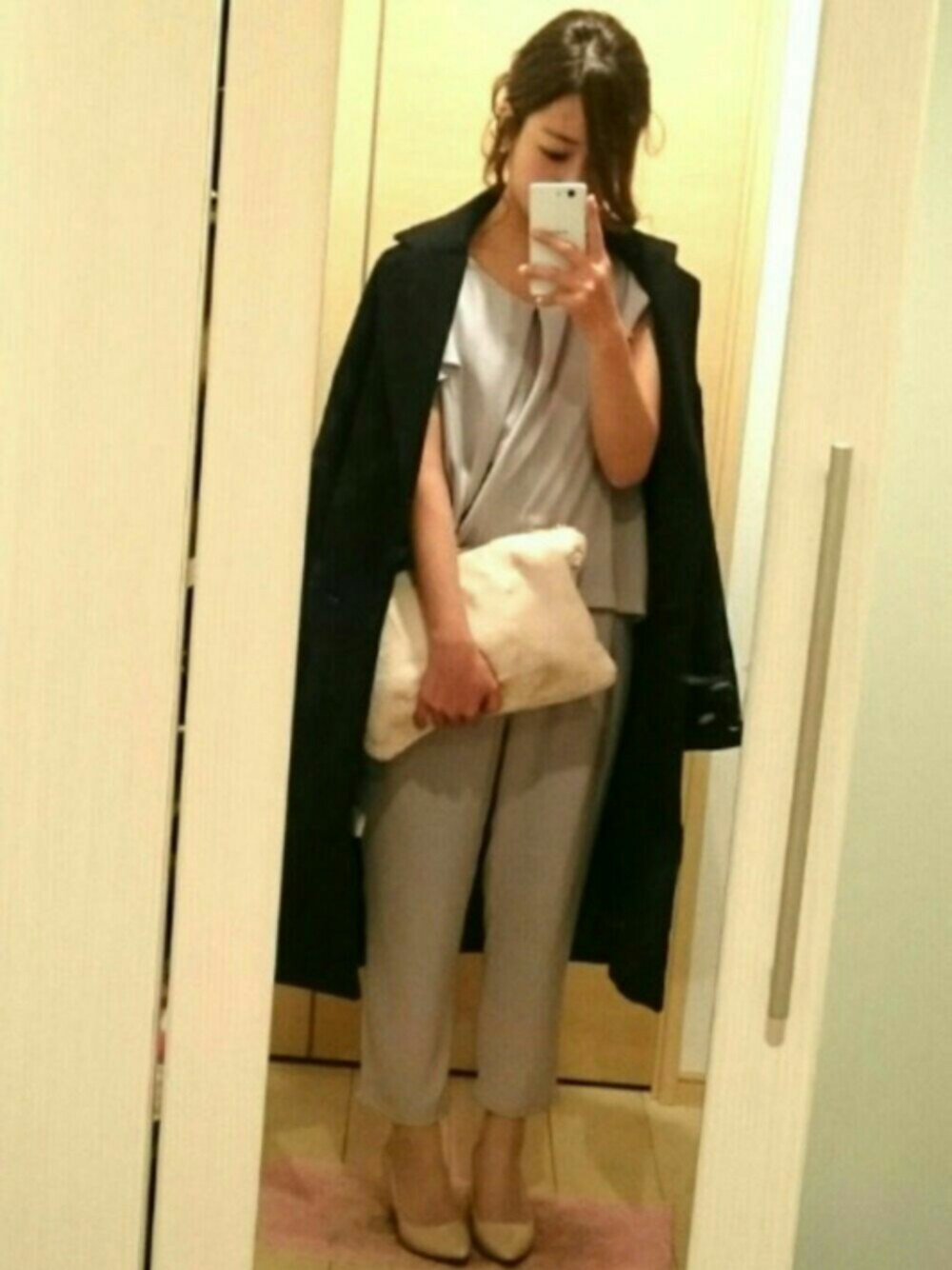 ホワイト系のクラッチバッグ、グレー系のワンピース、ベージュ系のパンプスを着用したレディースの冬コーディネートの1枚目の写真
