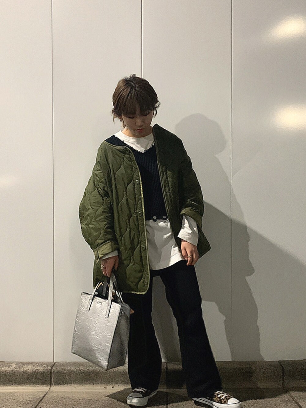 グリーン系のノーカラージャケット、ホワイト系のTシャツ/カットソー、ブラウン系のスニーカーを着用したレディースの冬コーディネートの1枚目の写真