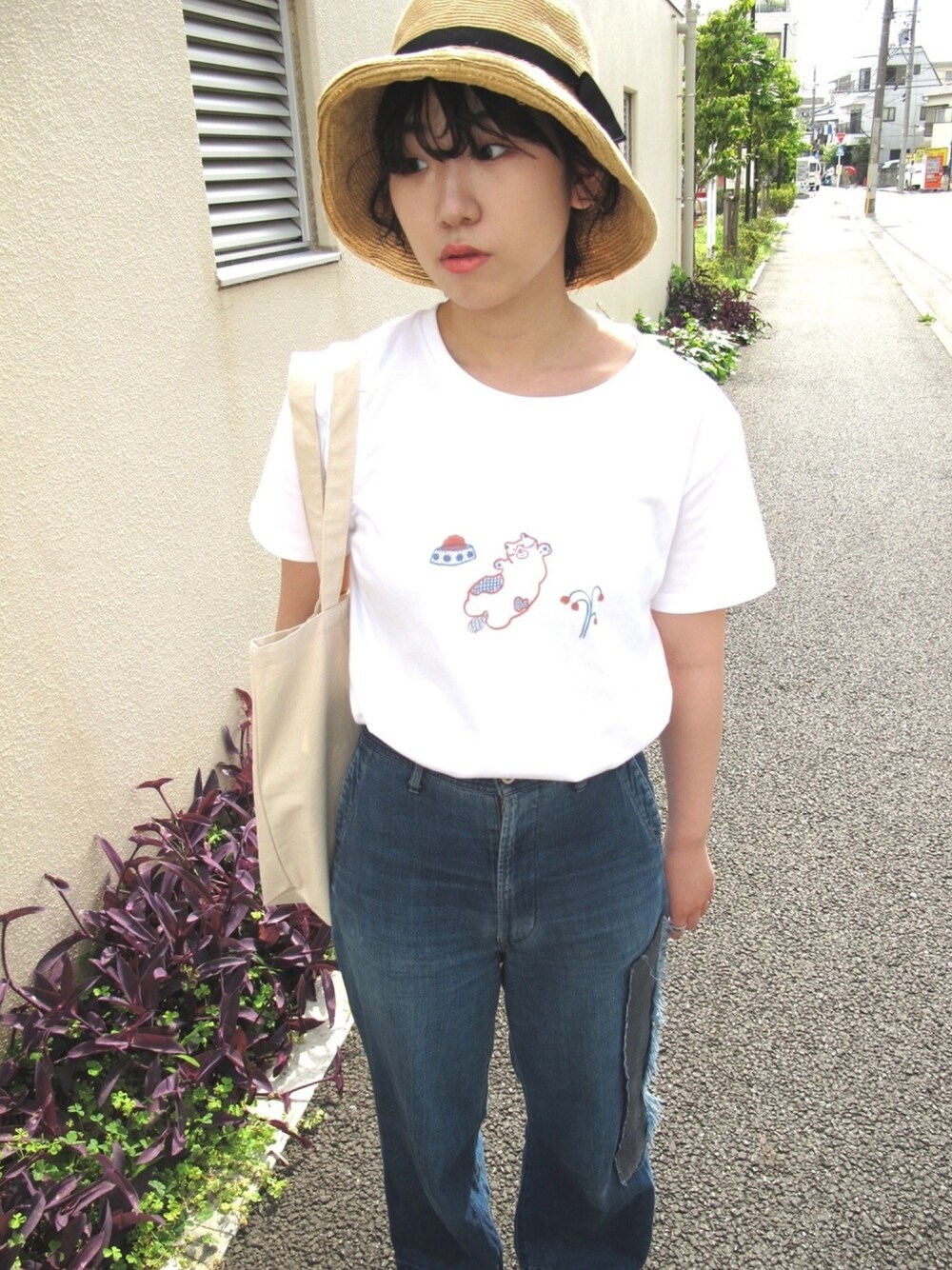 ホワイト系のTシャツ/カットソー、ベージュ系のトートバッグ、ブルー系のデニムパンツを着用したレディースの夏コーディネートの1枚目の写真