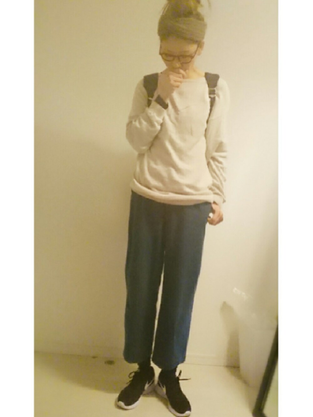 ブラック系のスニーカー、ベージュ系のニット/セーター、ブルー系のバックパック/リュックを着用したレディースの冬コーディネートの1枚目の写真