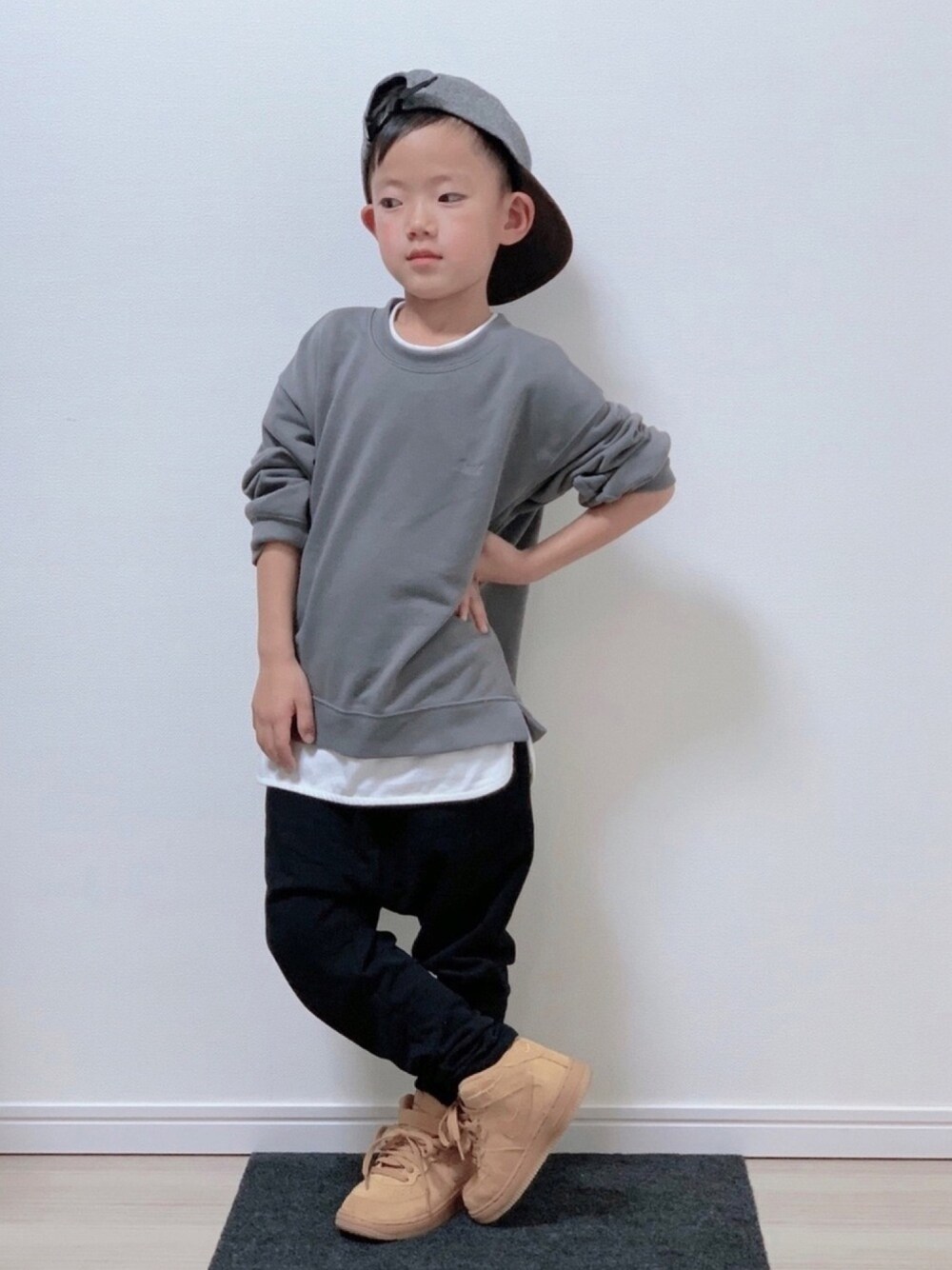 グレー系のTシャツ/カットソー、ブラック系のスウェットパンツ、ベージュ系のスニーカーを着用したキッズの冬コーディネートの1枚目の写真