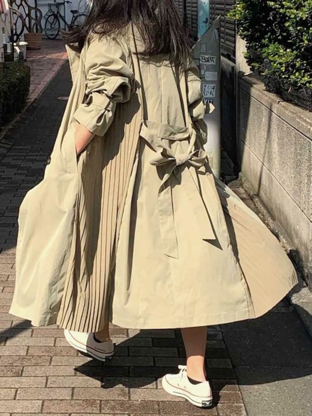 グリーン系のトレンチコートを着用したレディースの春コーディネートの1枚目の写真