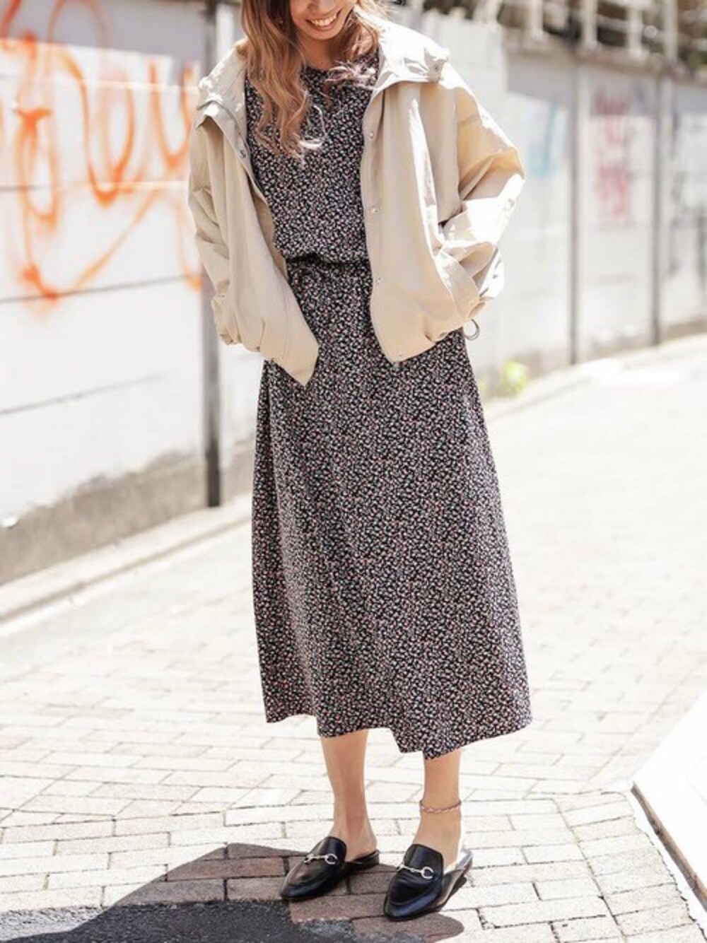 ベージュ系のマウンテンパーカー、ブラック系のワンピースを着用したレディースの春コーディネートの1枚目の写真