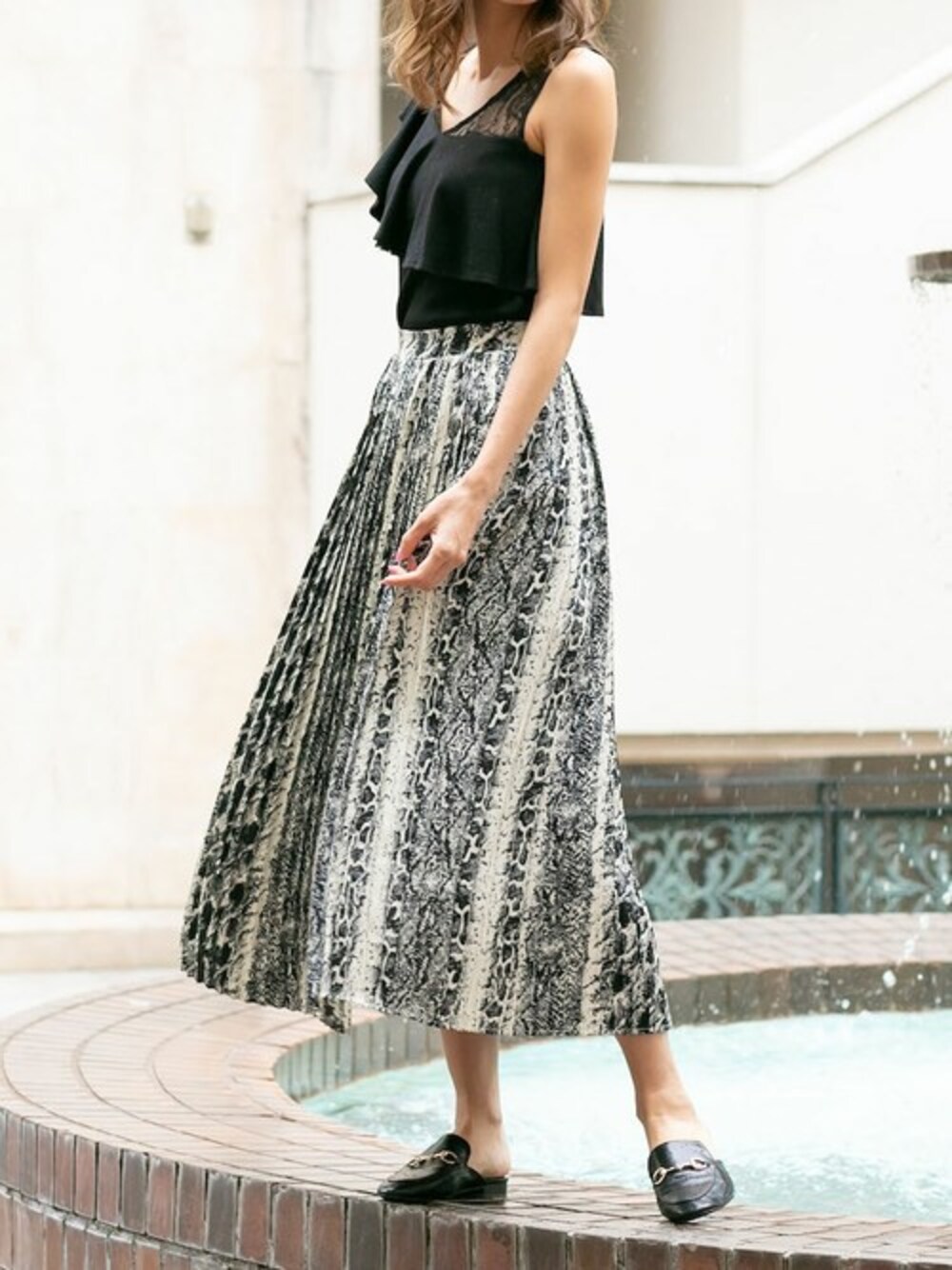 グレー系のスカート、ブラック系のTシャツ/カットソーを着用したレディースの夏コーディネートの1枚目の写真