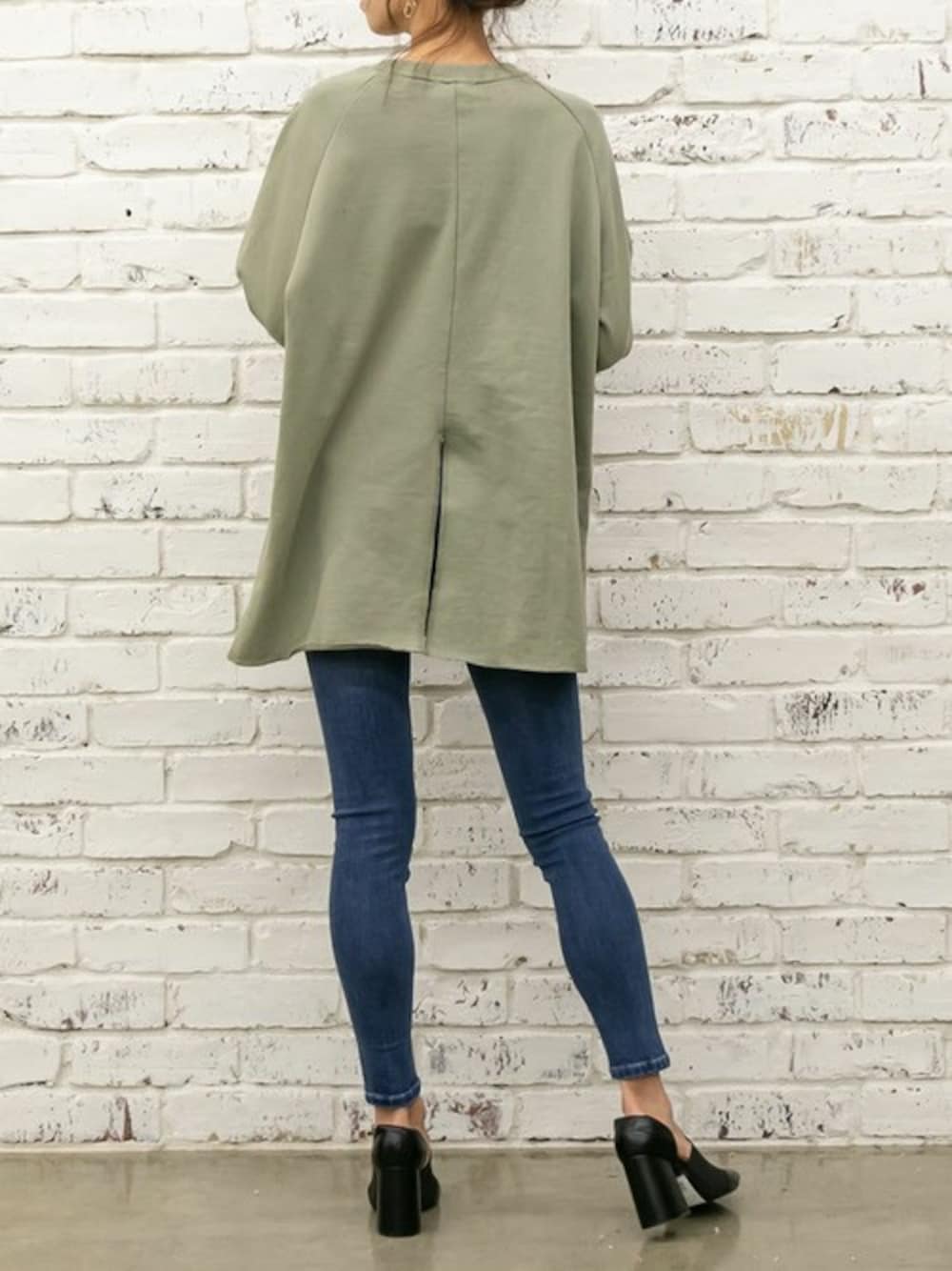 ブルー系のデニムパンツ、グリーン系のチュニックを着用したレディースの春コーディネートの1枚目の写真