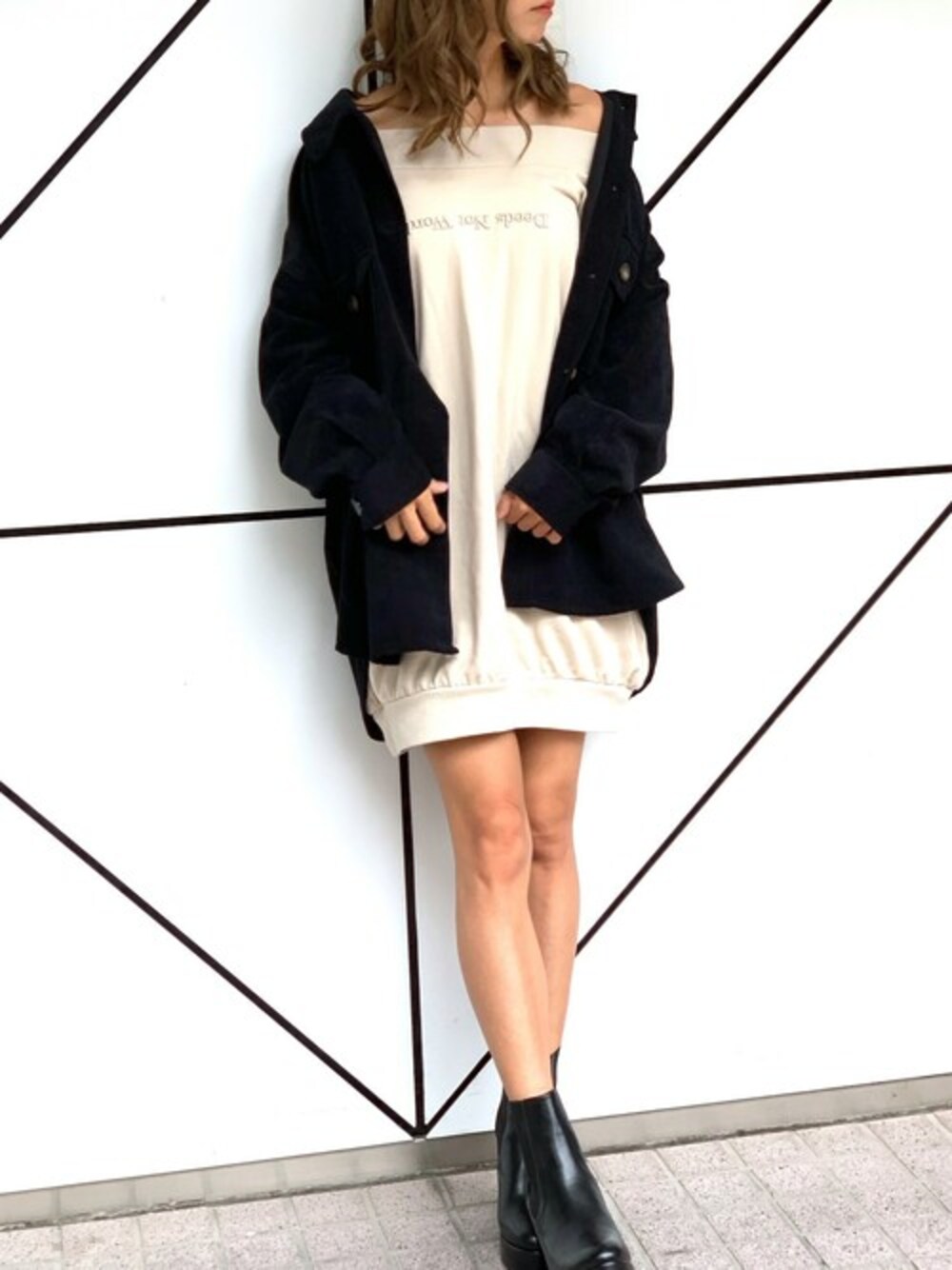 ブラック系のブルゾン、ベージュ系のワンピース、ブラック系のブーツを着用したレディースの秋コーディネートの1枚目の写真