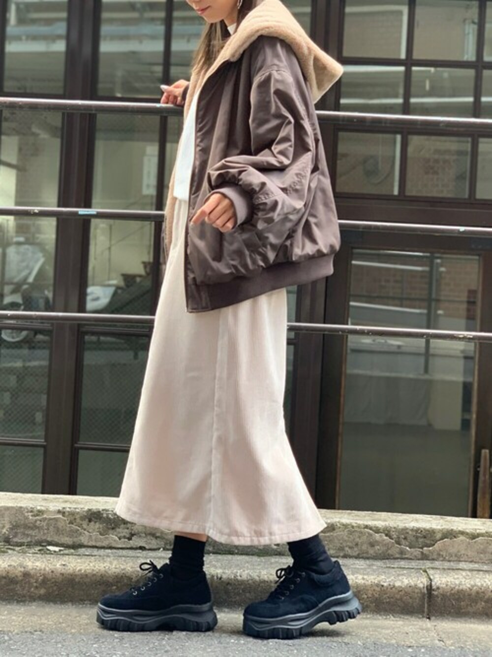 ブラウン系のMA-1、ホワイト系のTシャツ/カットソー、ホワイト系のスカートを着用したレディースの秋コーディネートの1枚目の写真