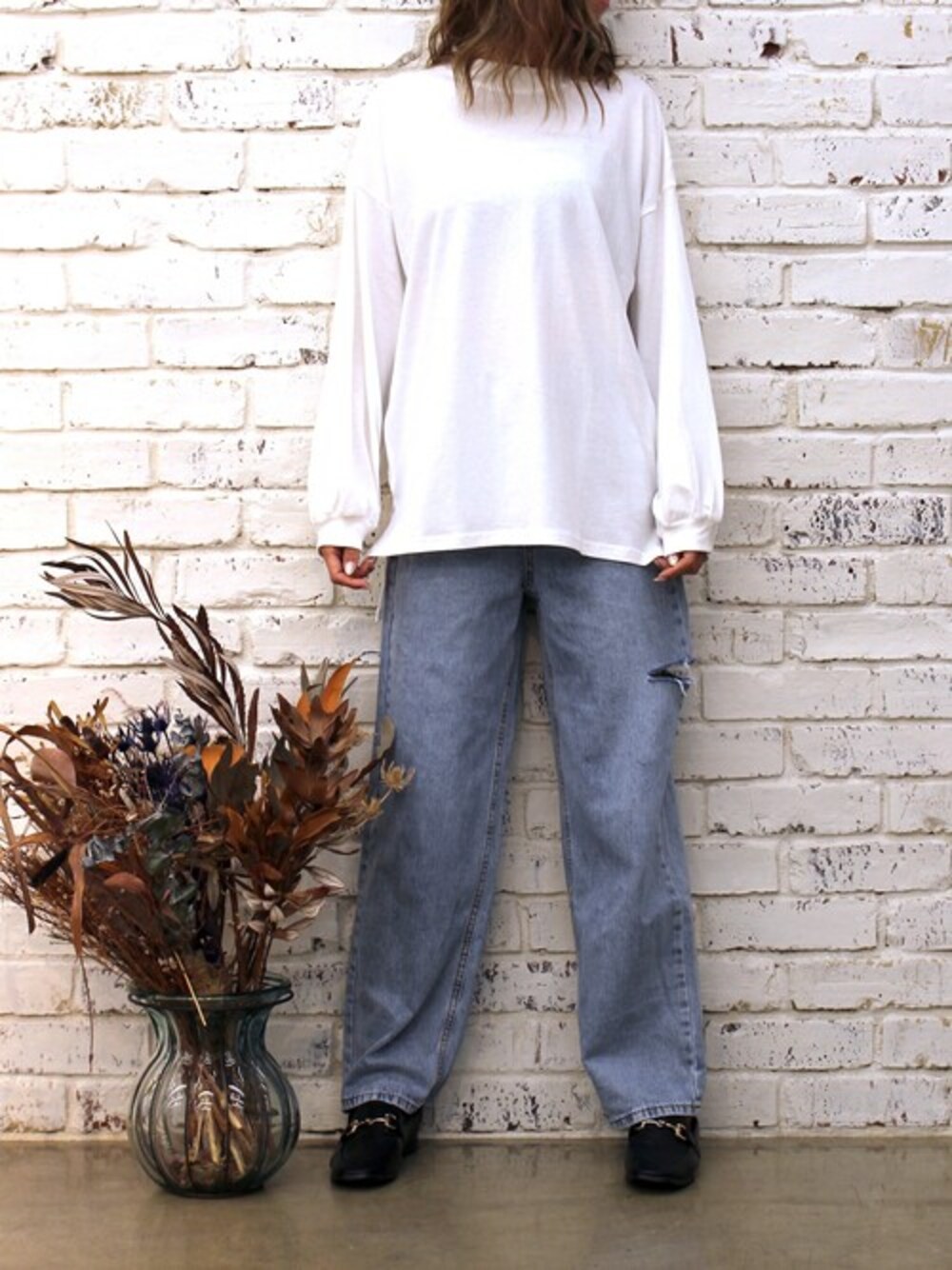 ホワイト系のTシャツ/カットソー、ブルー系のデニムパンツ、ブラック系のローファーを着用したレディースの冬コーディネートの1枚目の写真