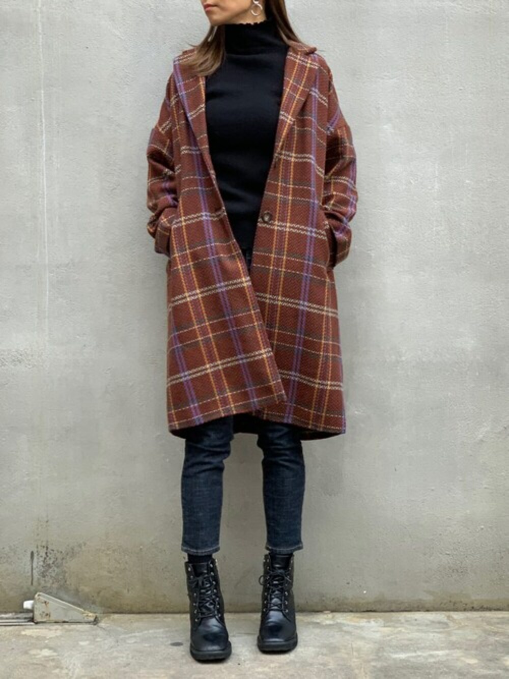 ブラック系のニット/セーター、ブラック系のブーツ、オレンジ系のチェスターコートを着用したレディースの冬コーディネートの1枚目の写真