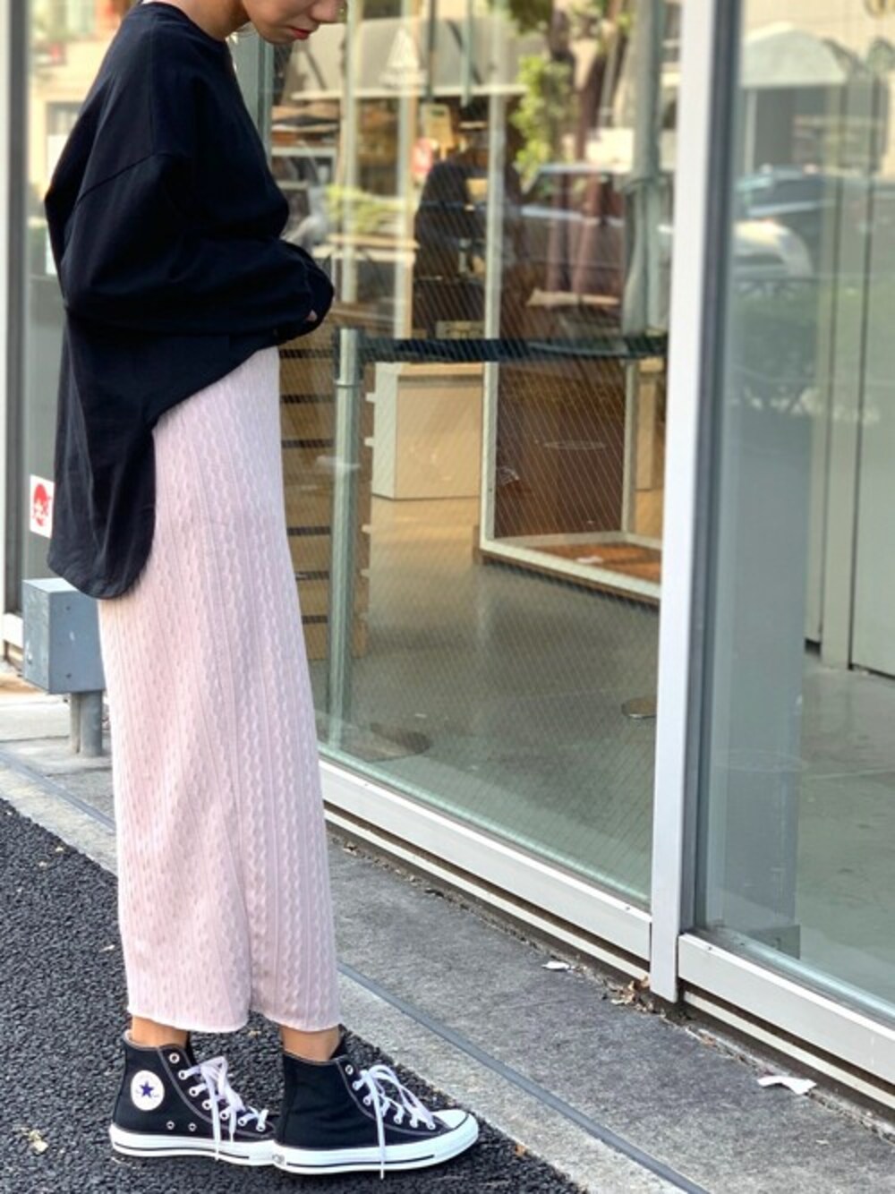 ベージュ系のスカート、ブラック系のスニーカー、ブラック系のTシャツ/カットソーを着用したレディースの冬コーディネートの1枚目の写真