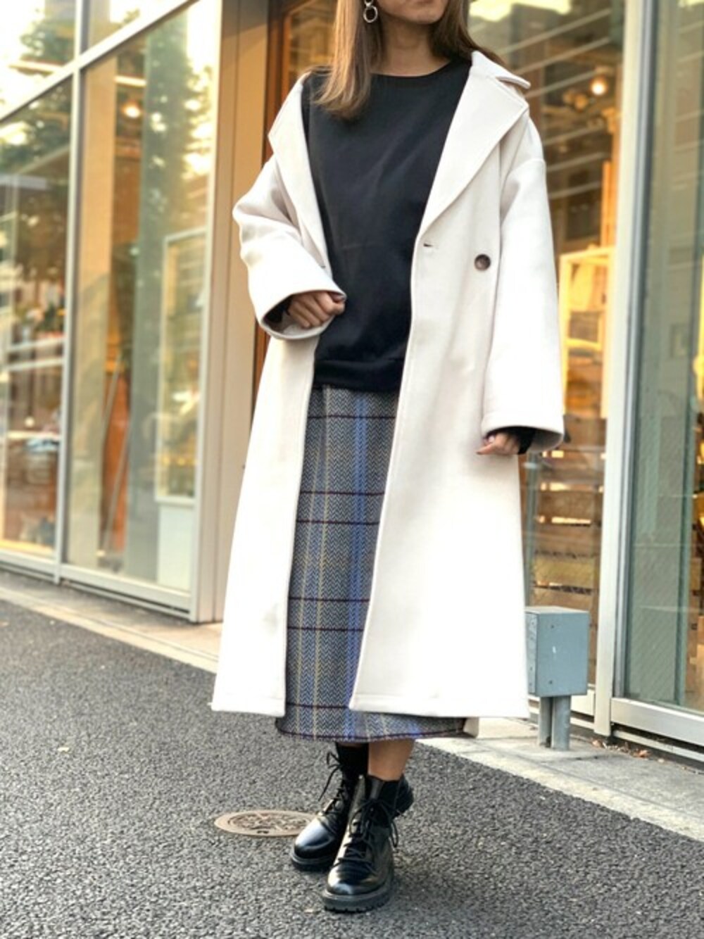 ホワイト系のチェスターコート、グレー系のスカート、ブラック系のスウェットを着用したレディースの冬コーディネートの1枚目の写真