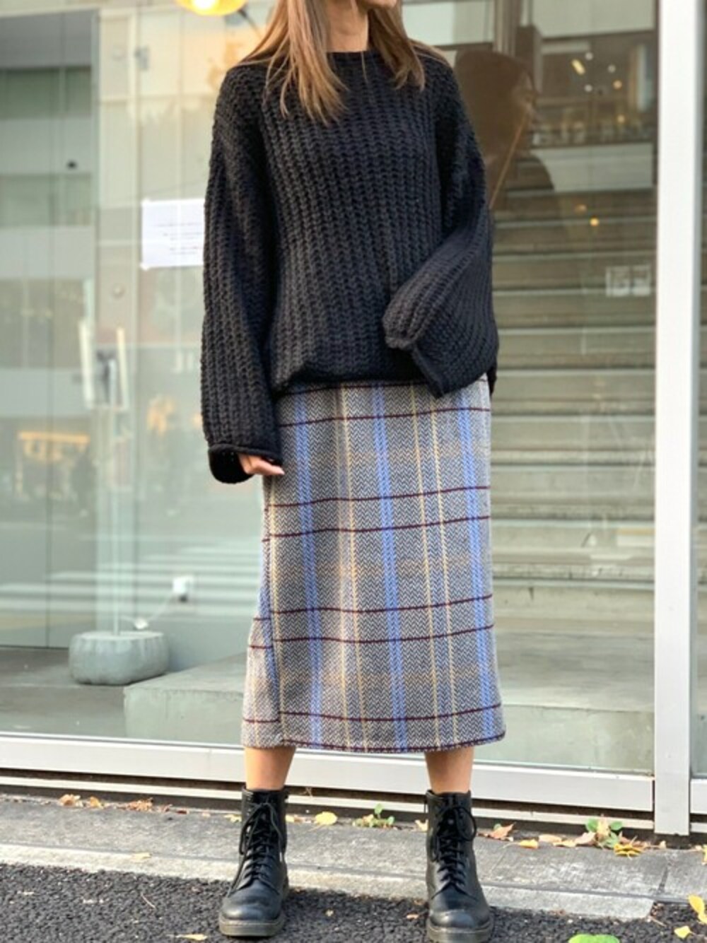 ホワイト系のニット/セーター、グレー系のスカートを着用したレディースの冬コーディネートの1枚目の写真