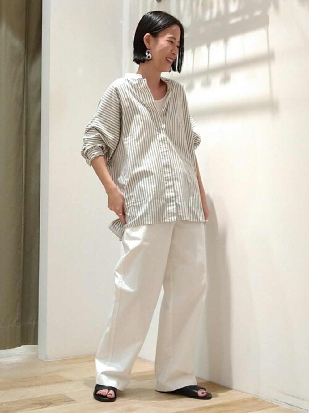 グリーン系のシャツ/ブラウス、ホワイト系のタンクトップ、ホワイト系のデニムパンツを着用したレディースの春コーディネートの1枚目の写真