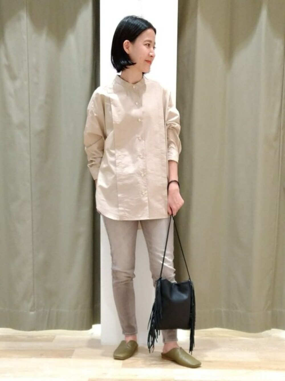 ベージュ系のシャツ/ブラウス、グレー系のデニムパンツ、ブラック系のハンドバッグを着用したレディースの秋コーディネートの1枚目の写真