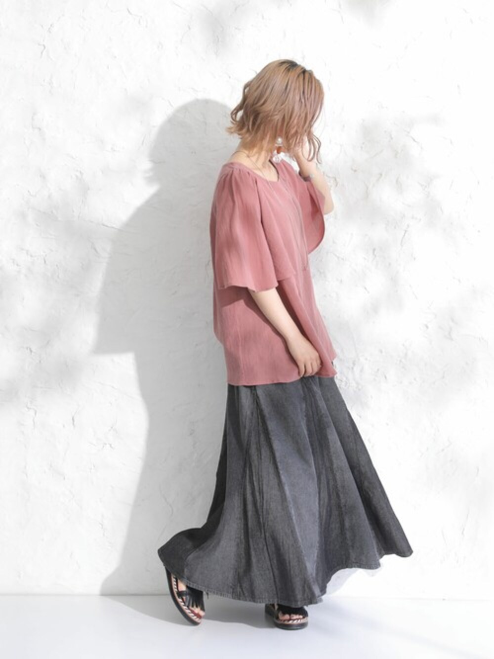 ブラック系のデニムスカートを着用したレディースの春コーディネートの1枚目の写真