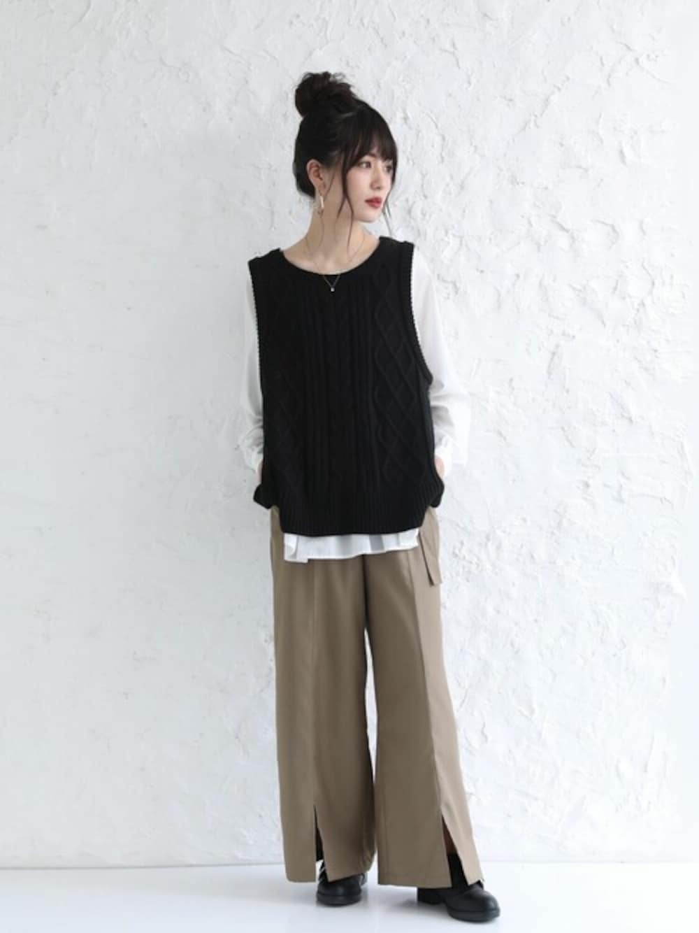 ベージュ系のその他パンツ、ブラック系のベストを着用したレディースの秋コーディネートの1枚目の写真