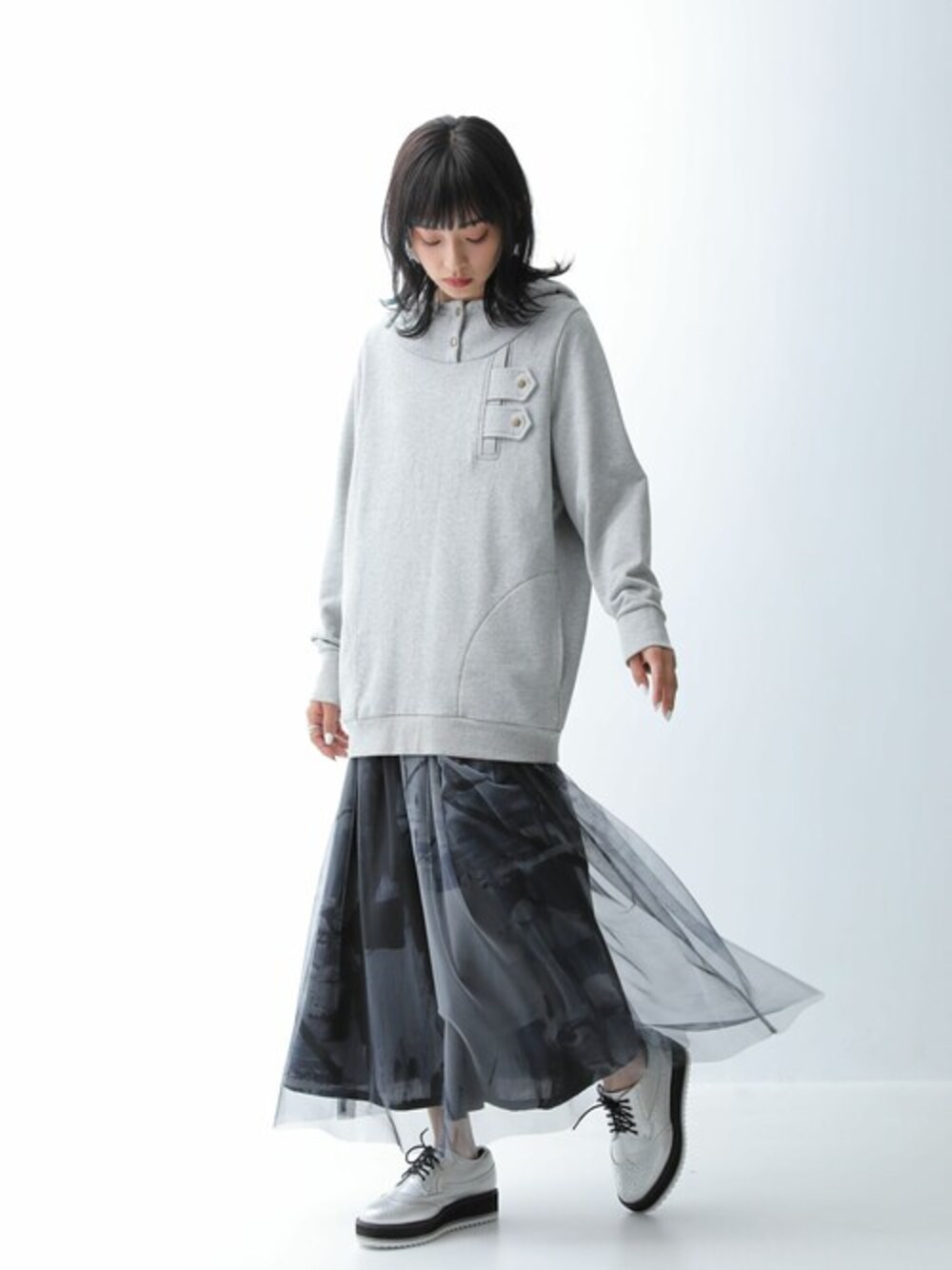 ブラック系のスカート、グレー系のパーカーを着用したレディースの秋コーディネートの1枚目の写真