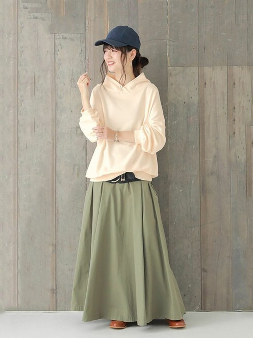 ホワイト系のスウェット、グリーン系のスカートを着用したレディースの冬コーディネートの1枚目の写真