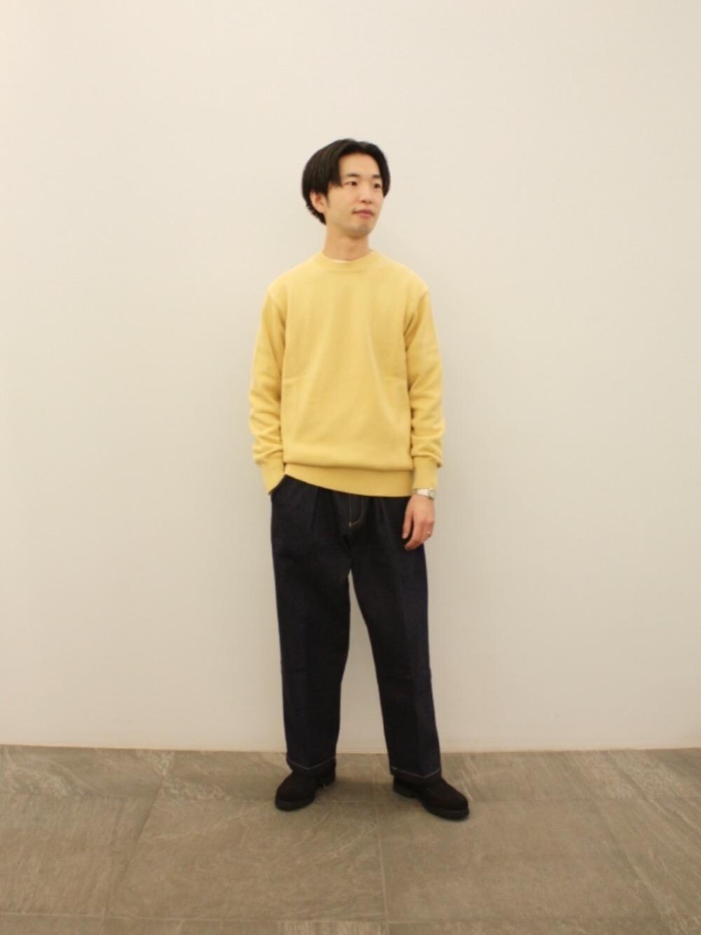 ブルー系のデニムパンツ、ブラック系のブーツ、オレンジ系のニット/セーターを着用したメンズの冬コーディネートの1枚目の写真