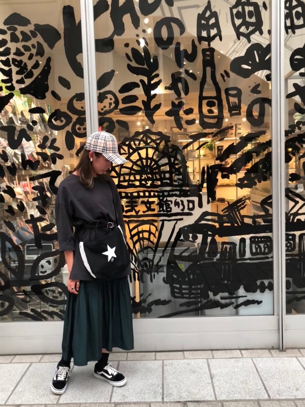 ブラック系のTシャツ/カットソー、グリーン系のスカート、ブラック系のトートバッグを着用したレディースの秋コーディネートの1枚目の写真