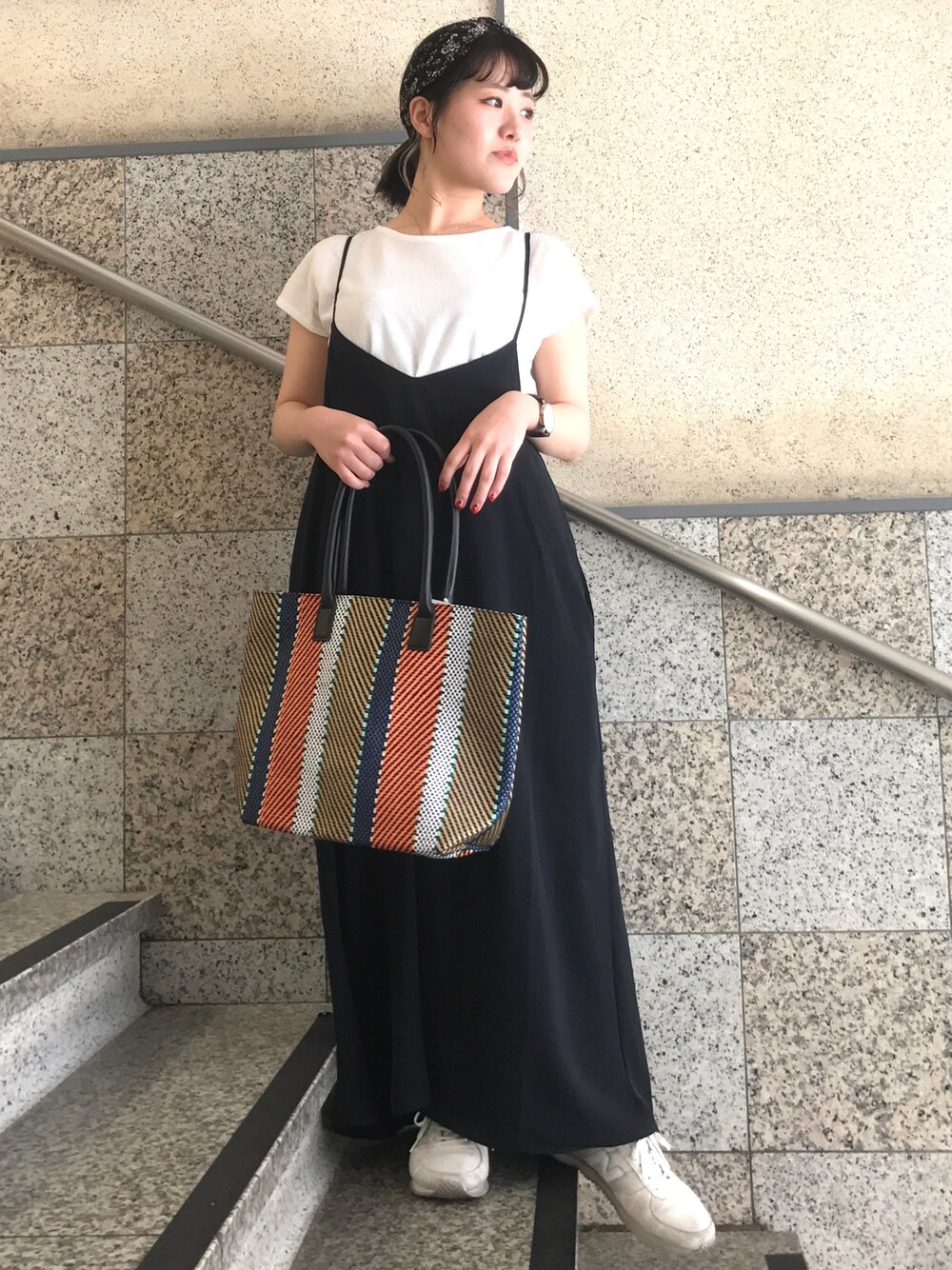 ブラック系のワンピース、オレンジ系のトートバッグ、ホワイト系のスニーカーを着用したレディースの夏コーディネートの1枚目の写真