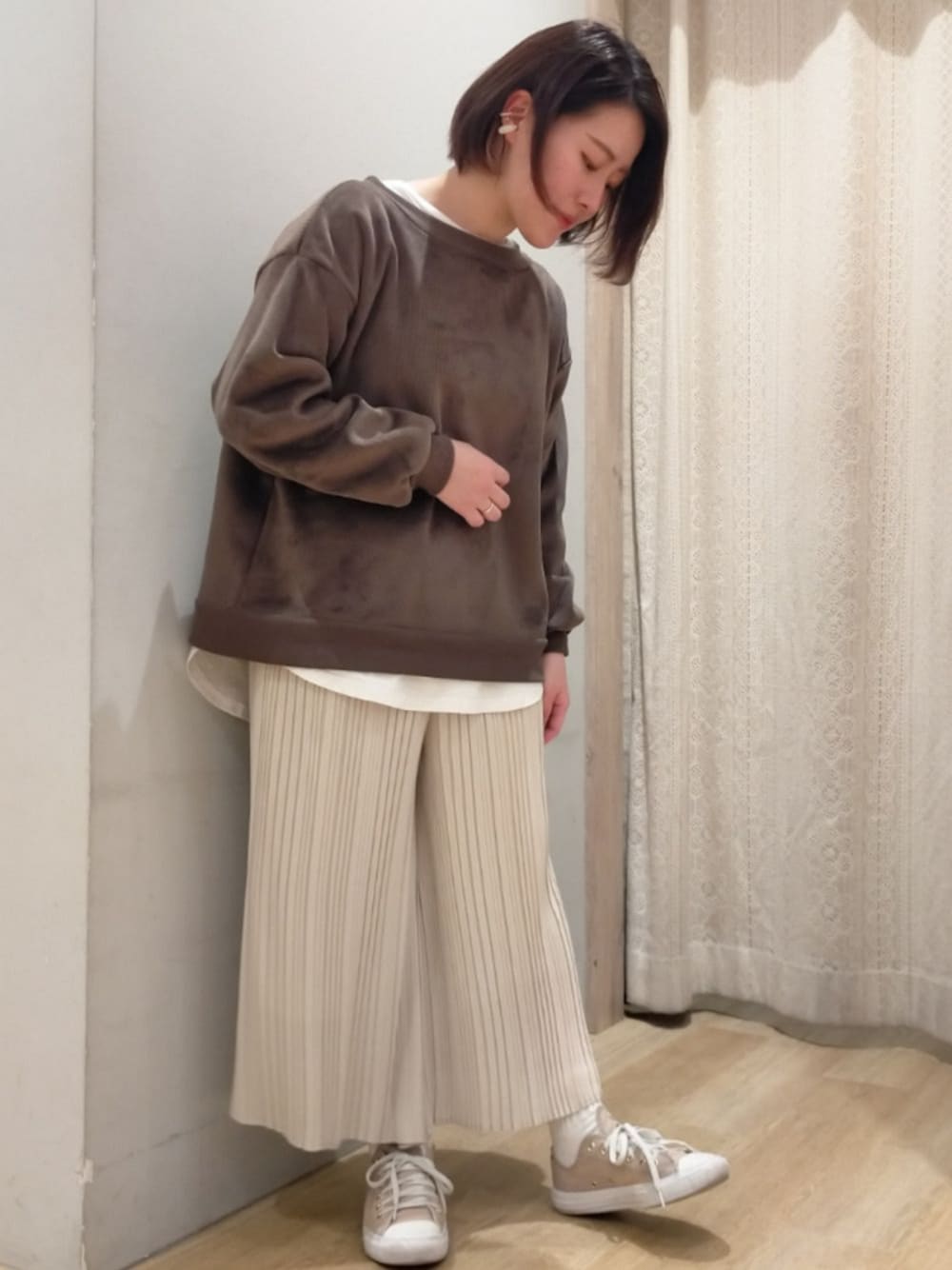 ブラウン系のスウェット、ホワイト系のその他パンツを着用したレディースの冬コーディネートの1枚目の写真