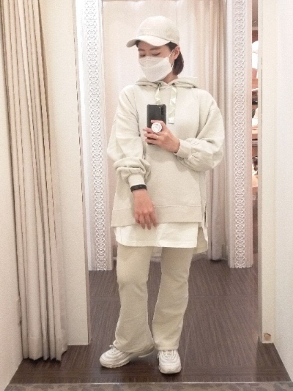 グリーン系のトップス、ホワイト系のパンツ、ベージュ系の帽子を着用したレディースの秋コーディネートの1枚目の写真