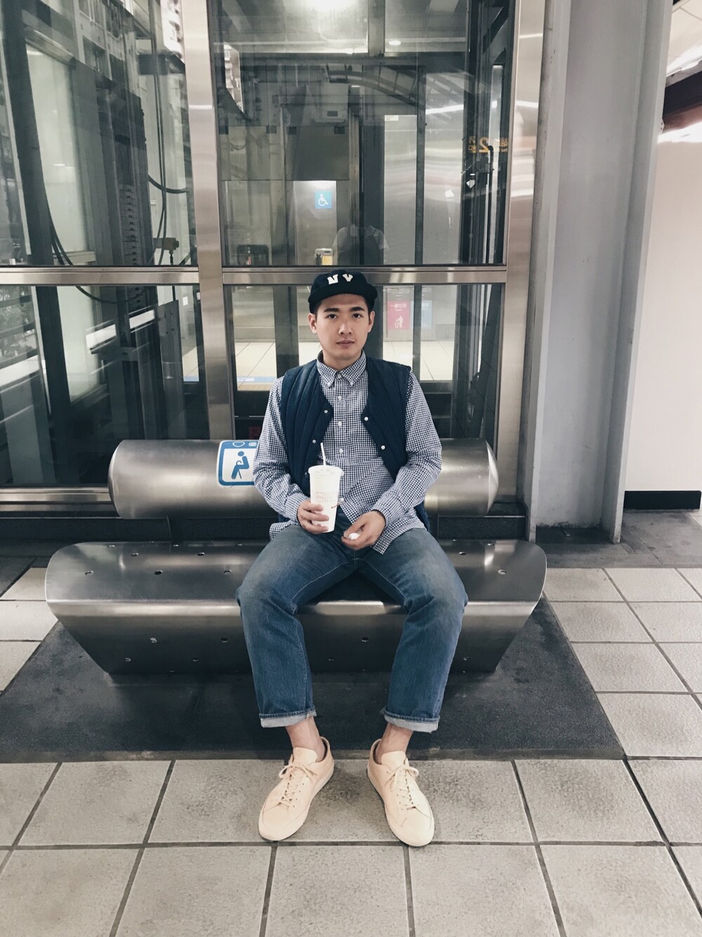 ブルー系のベスト、ブルー系のデニムパンツ、ベージュ系のスニーカーを着用したメンズの秋コーディネートの1枚目の写真