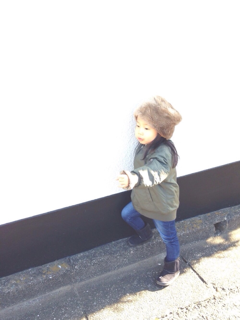 グリーン系のジャケット/アウター、ブルー系のデニムパンツ、ブラック系のブーツを着用したキッズの冬コーディネートの1枚目の写真