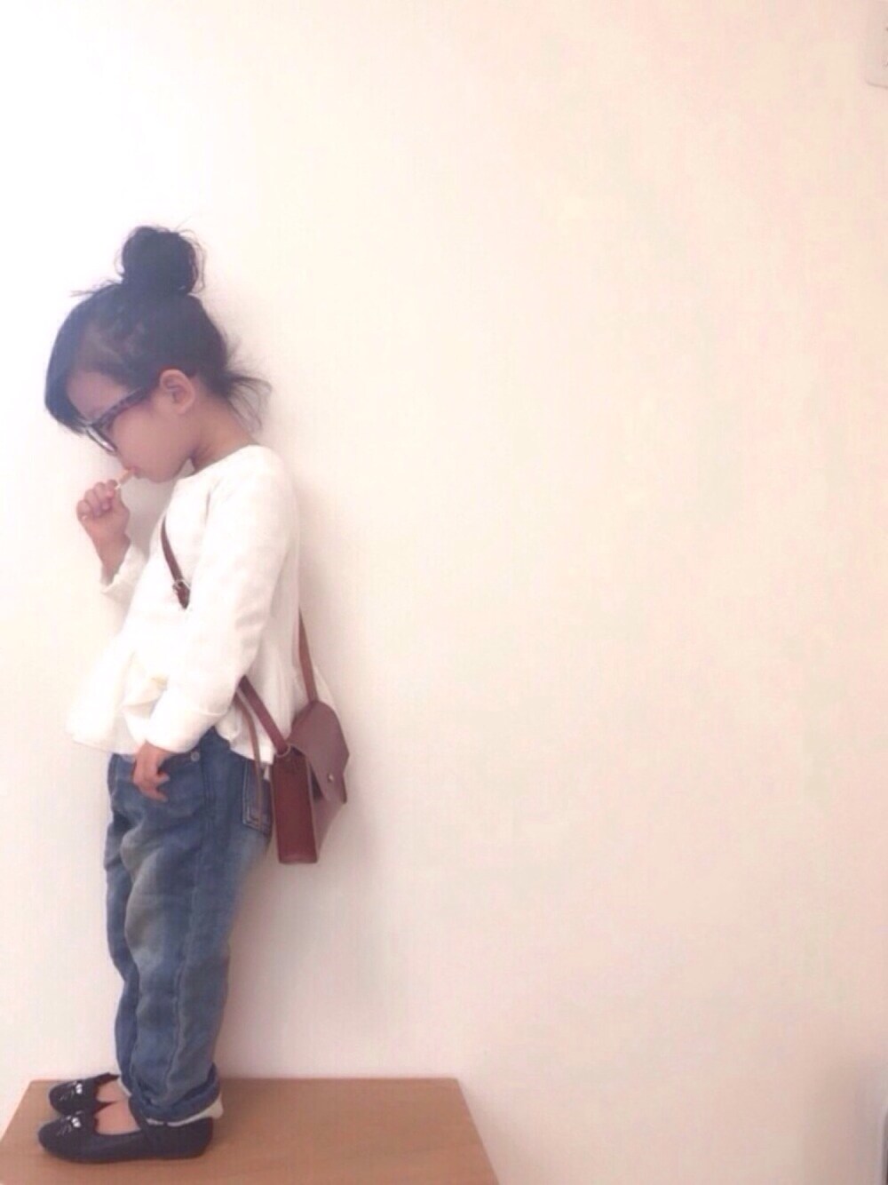 ホワイト系のTシャツ/カットソー、レッド系のショルダーバッグ、ブルー系のデニムパンツを着用したキッズの冬コーディネートの1枚目の写真