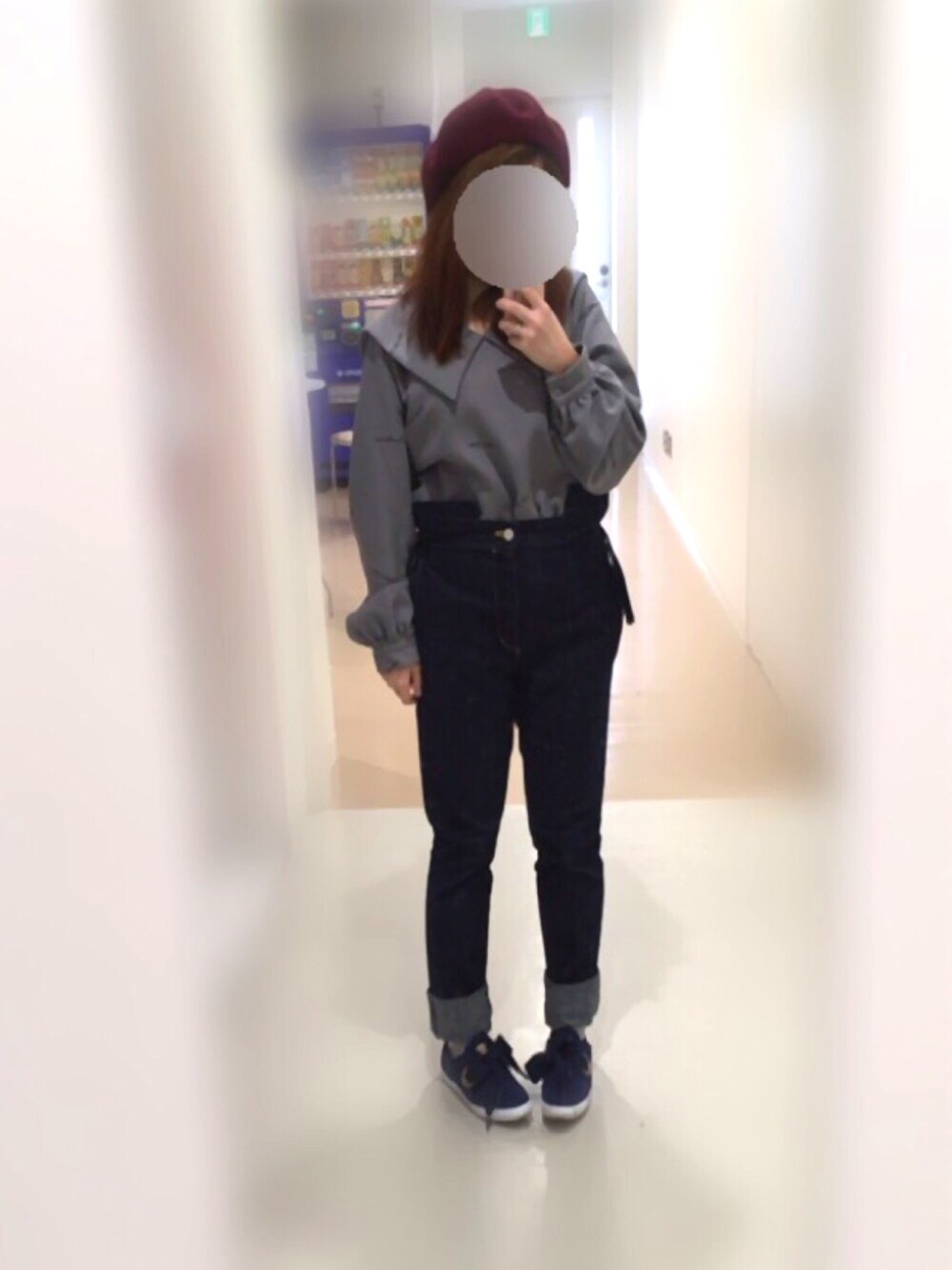 グレー系のトップス、ブルー系のデニムパンツ、ブルー系のスニーカーを着用したレディースの冬コーディネートの1枚目の写真