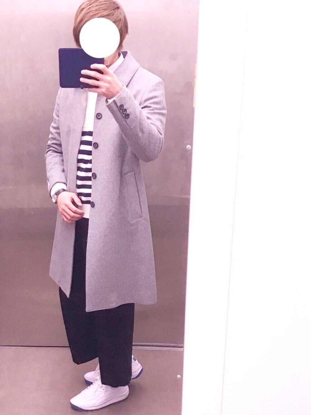 グレー系のステンカラーコート、ホワイト系のニット/セーター、ブラック系のパンツを着用したメンズの冬コーディネートの1枚目の写真