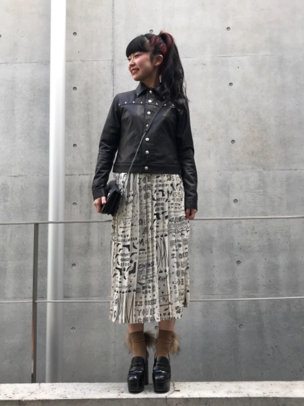 ホワイト系のワンピース、ブラック系のライダースジャケット、ブラウン系のソックス/靴下を着用したレディースの冬コーディネートの1枚目の写真