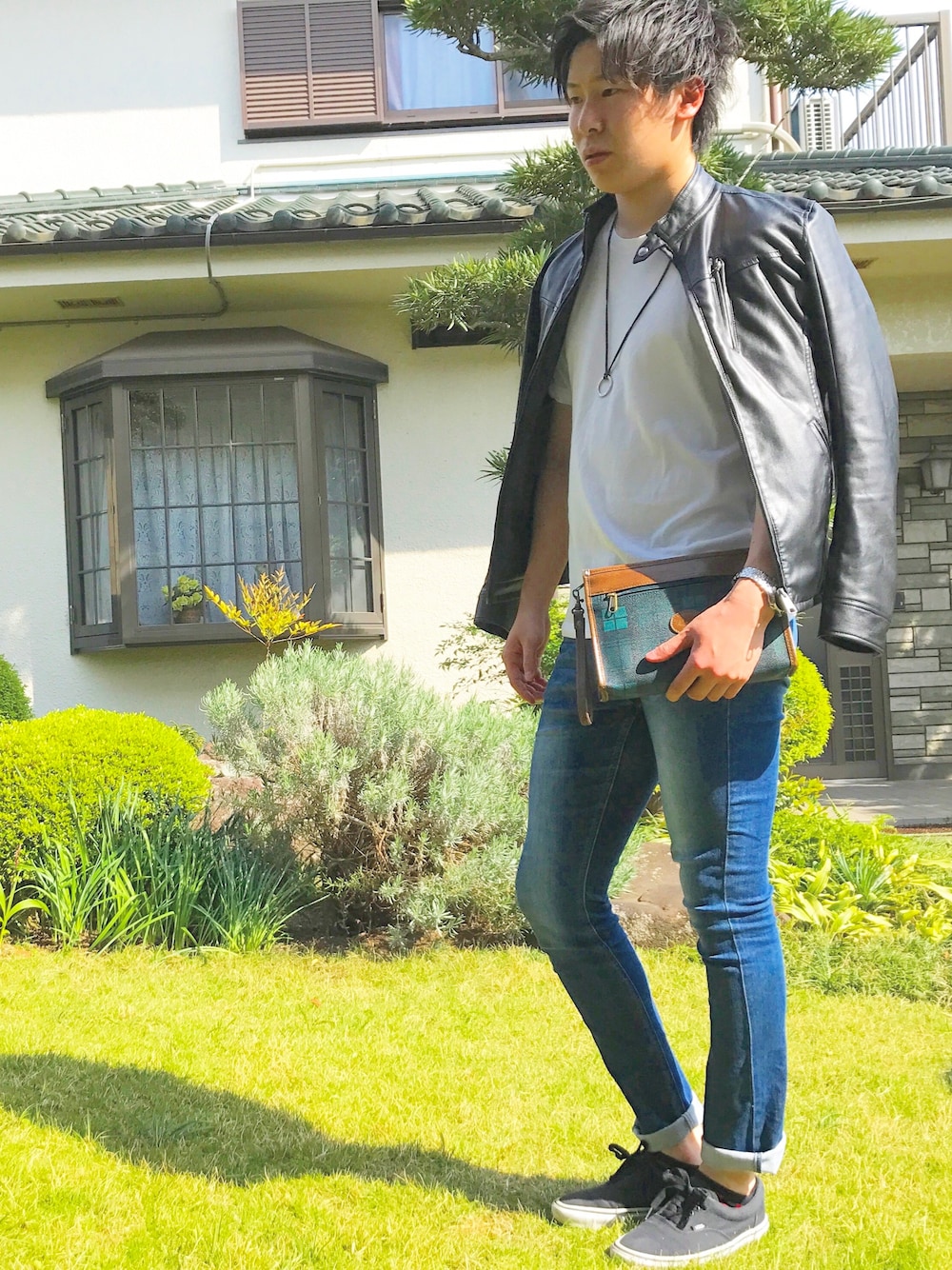 ブラック系のライダースジャケット、ホワイト系のTシャツ/カットソー、ブルー系のデニムパンツを着用したメンズの春コーディネートの1枚目の写真