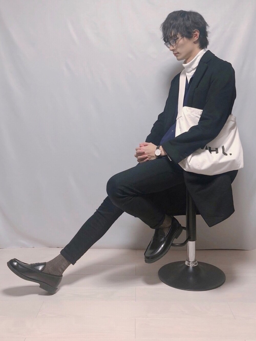 ブラック系のチェスターコート、ブルー系のシャツ/ブラウス、ホワイト系のTシャツ/カットソーを着用したメンズの冬コーディネートの1枚目の写真