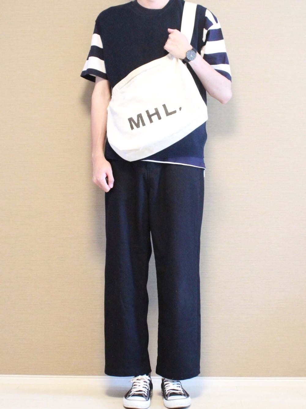 ブラック系のTシャツ/カットソー、ブルー系のニット/セーター、ブルー系のスラックスを着用したメンズの夏コーディネートの1枚目の写真